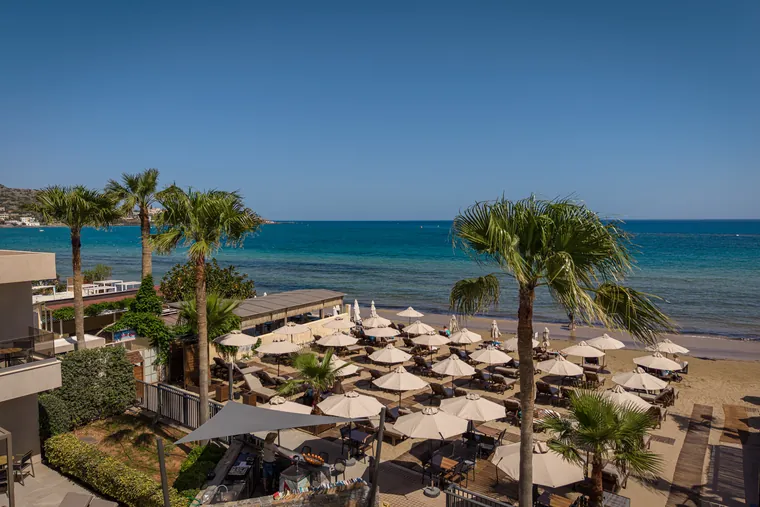 Private beach umbrellas and sunbeds by the sea at Riviera, Stalida Crete